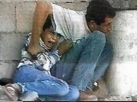 Jamal al-Durrah e Mohamad al-Durrah, pai e filho, momentos antes de serem atingidos. (Reprodução/Vídeo/Al-Jazeera)