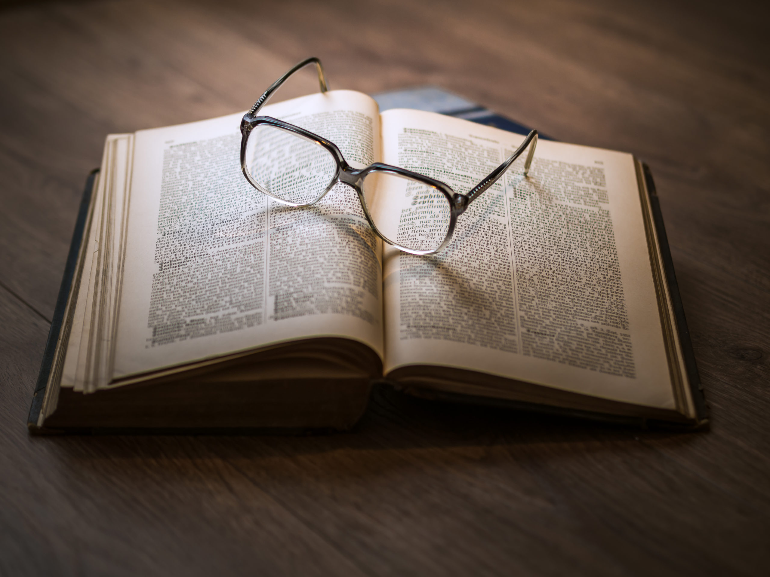 Decidir com tempo, experiência e ao lado de quem realmente importa. A imagem mostra um livro e um óculos em cima.