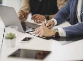 Office workers checking papers with pen in office
