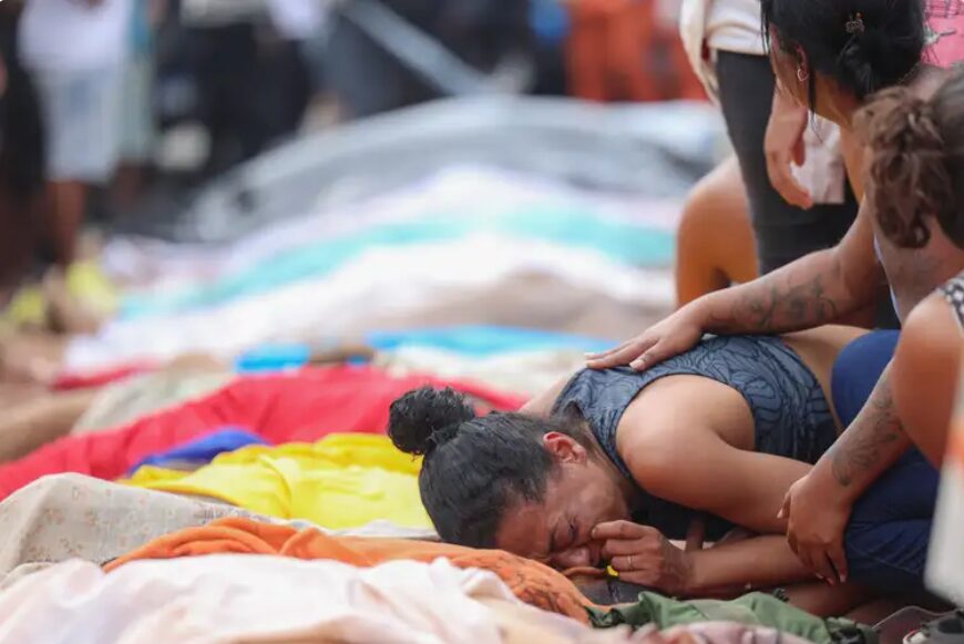 A dor da cor: a maior chacina da democracia brasileira e o Rio de Janeiro. Fotografia de mulher chorando em cima de um corpo.