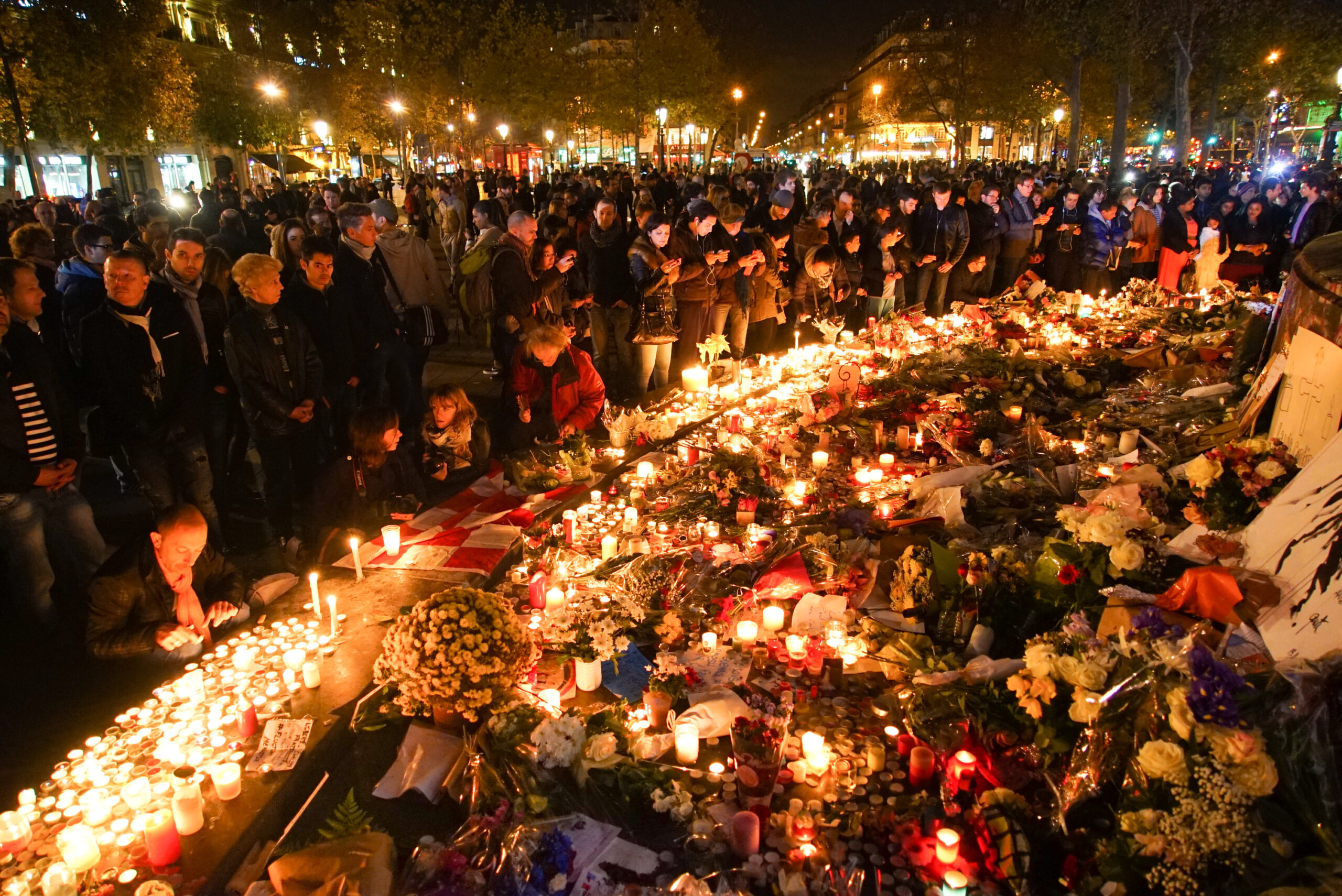 Na França, a população prestou homenagens às vítimas do terrorismo, com flores e velas. É uma fotografia.