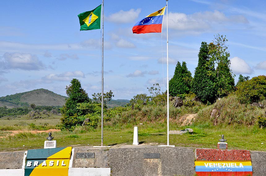 América Latina: fronteira do Brasil com a Venezuela, existem bandeiras de cada país hasteada