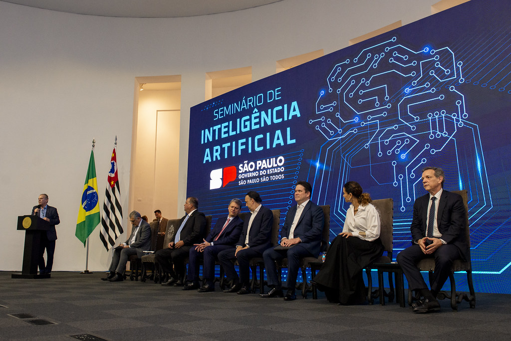 Fotografia do seminário de Inteligência Artificial (IA), com políticos como Tarcísio de Freitas e bandeiras do Brasil e de São Paulo