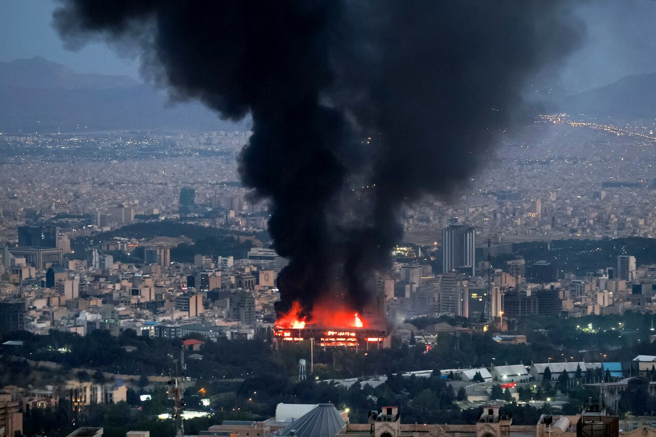 Fotografia de um ataque à Radiotelevisão da República Islâmica do Irã. A fumaça é preta e o local pega fogo