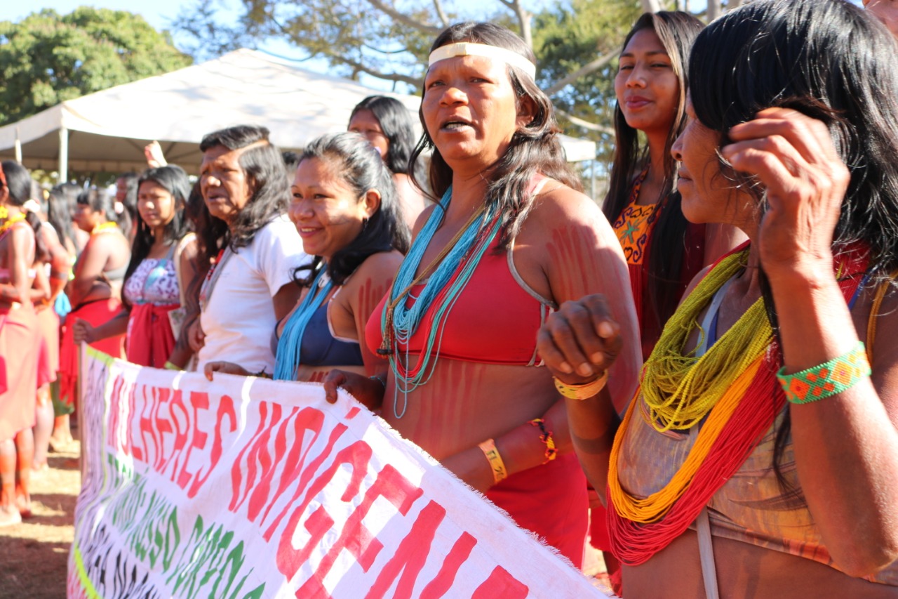 Foto do portal Amazônia Real: mulheres indígenas seguram uma faixa, em que é possível ler "mulheres indígenas"